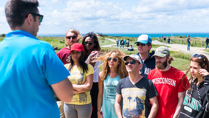 Peer over the cliffs of the Pointe du Hoc